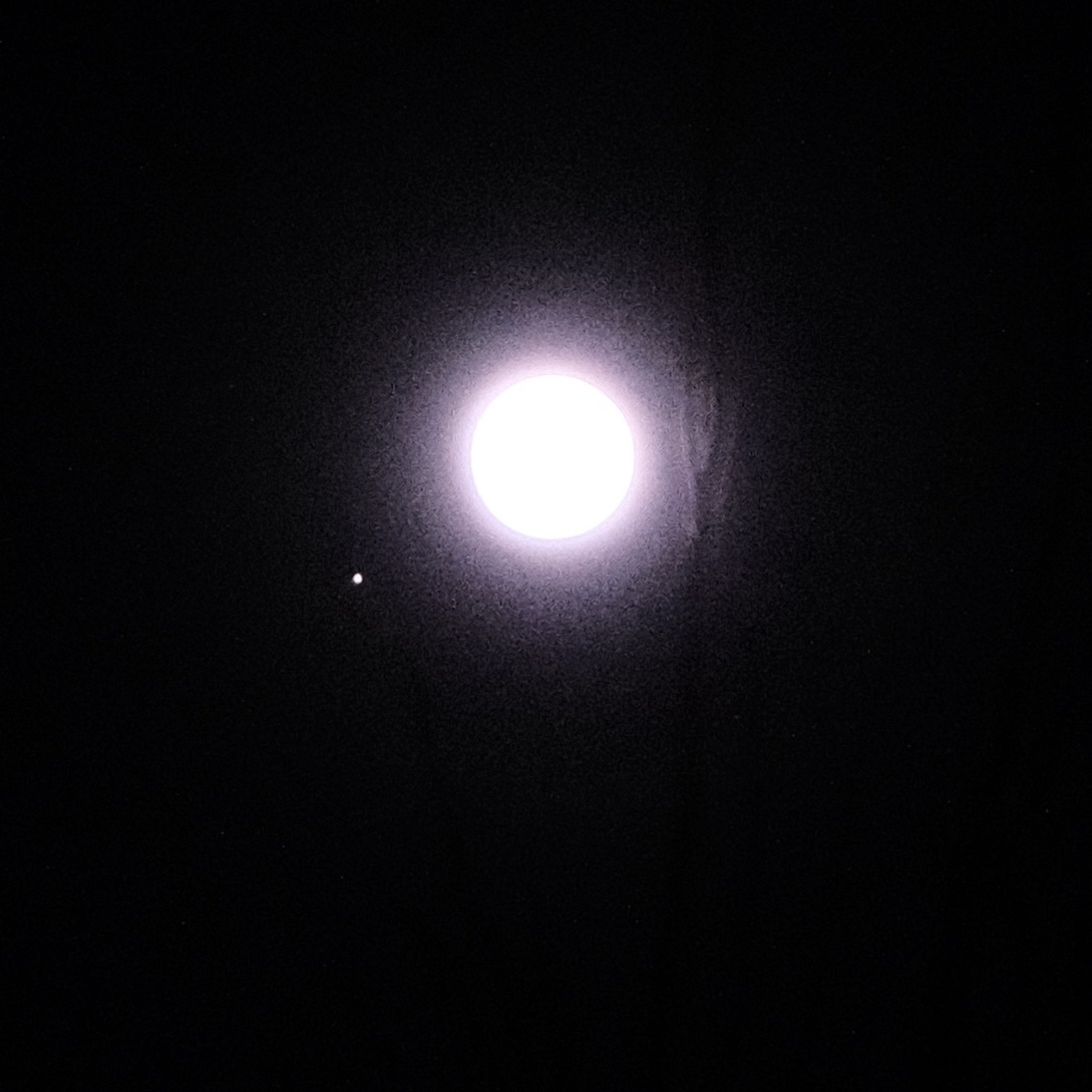 mars and the moon in a dark sky. mars looks like a star to the bottom left of the full extremely bright moon